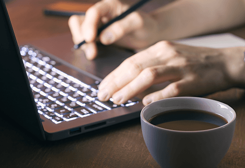 Person arbeitet fokussiert am Laptop mit Kaffee – Symbol für modernes Arbeiten und Karriere bei Credaris